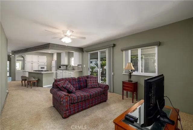 a living room with furniture a window and a flat screen tv