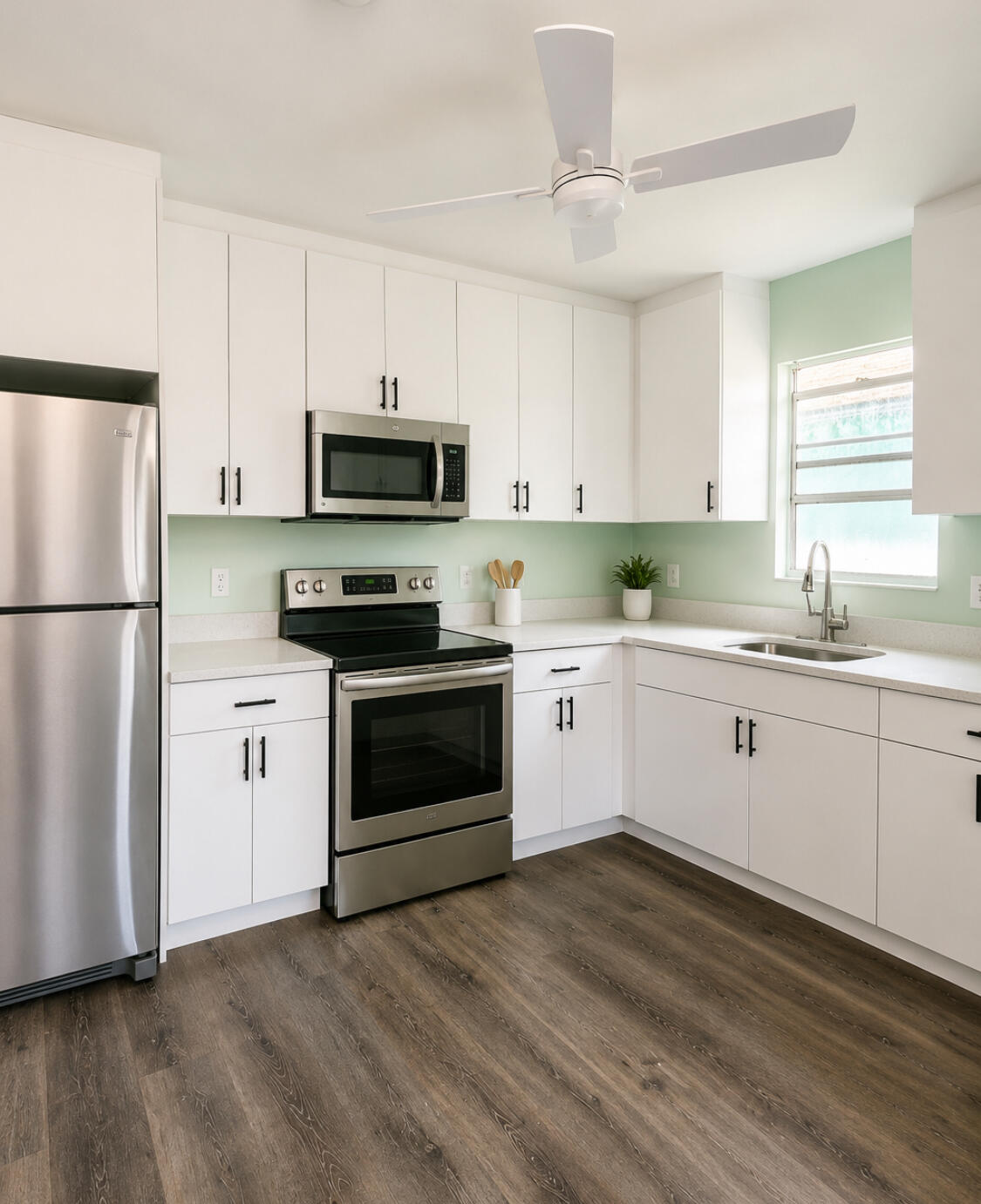 1328 West 6th Street Riviera Beach, FL 33404 - Photo 6 of 11 a kitchen with a refrigerator stove and white cabinets