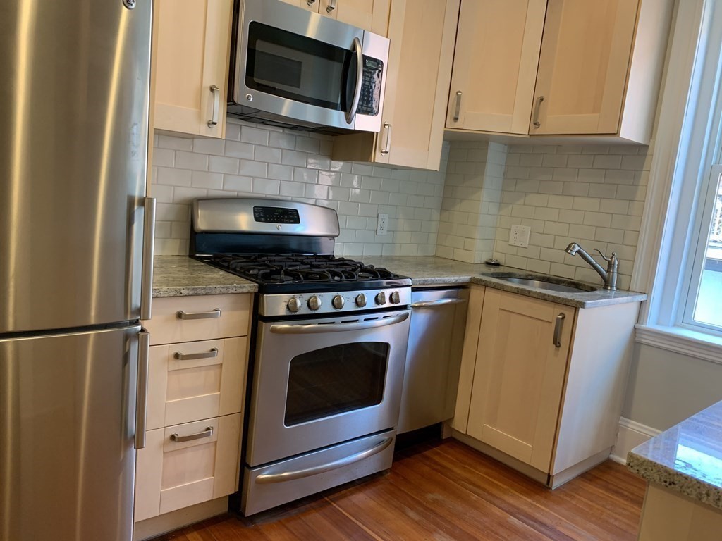 38 Kilsyth Road, Unit 33 Brookline, MA 02445 - Photo 11 of 23 a kitchen with stainless steel appliances granite countertop a stove microwave and sink