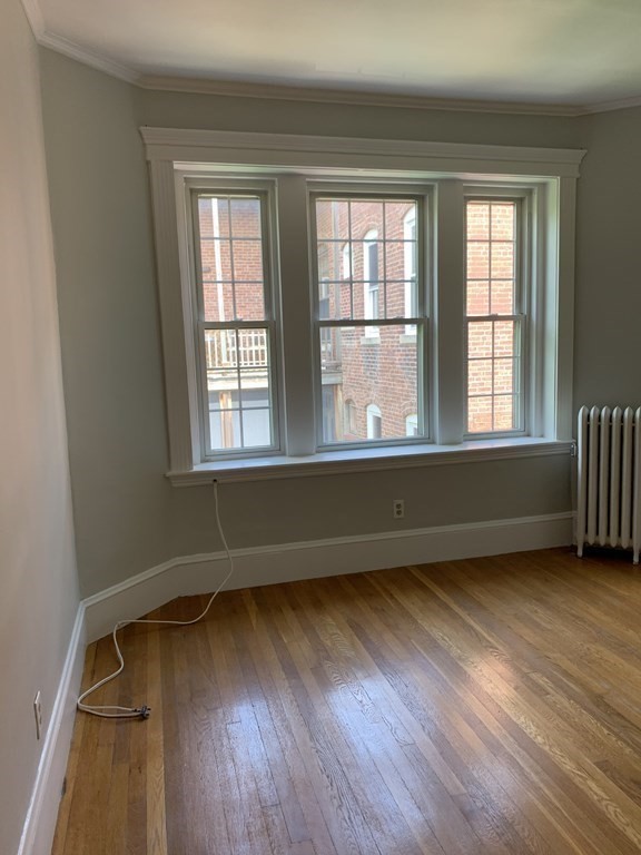 38 Kilsyth Road, Unit 33 Brookline, MA 02445 - Photo 6 of 23 an empty room with wooden floor and windows