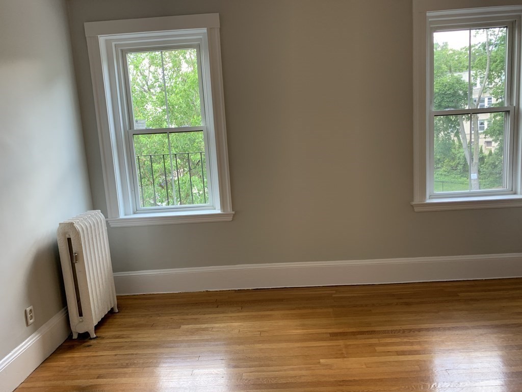 38 Kilsyth Road, Unit 33 Brookline, MA 02445 - Photo 7 of 23 a view of an empty room with wooden floor and a window