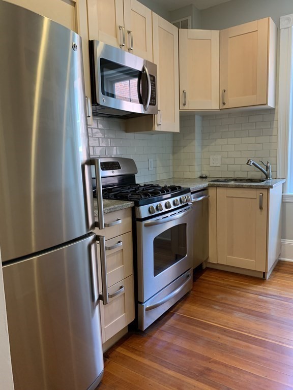 38 Kilsyth Road, Unit 33 Brookline, MA 02445 - Photo 10 of 23 a kitchen with stainless steel appliances granite countertop a stove a refrigerator and a microwave