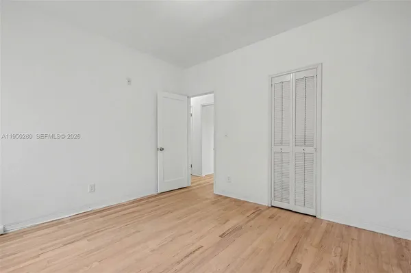 a view of an empty room with wooden floor