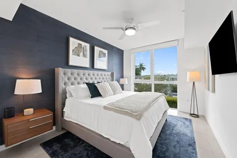 a bedroom with a bed and a flat tv screen on dresser