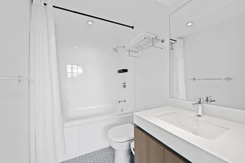 a bathroom with a sink a toilet and shower
