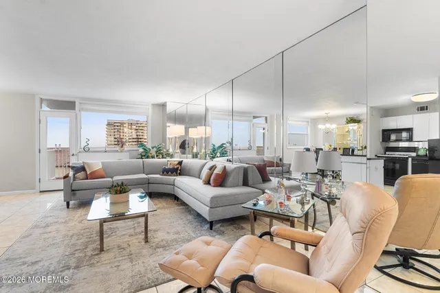 a living room with furniture kitchen view and a large window