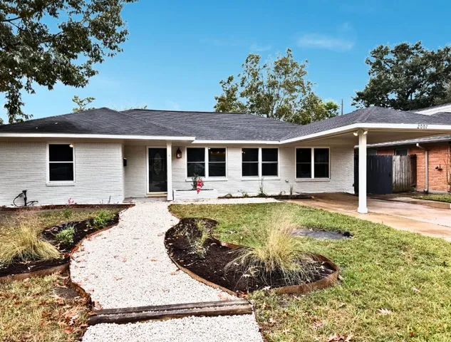 a view of a white house with a large pool table and chairs