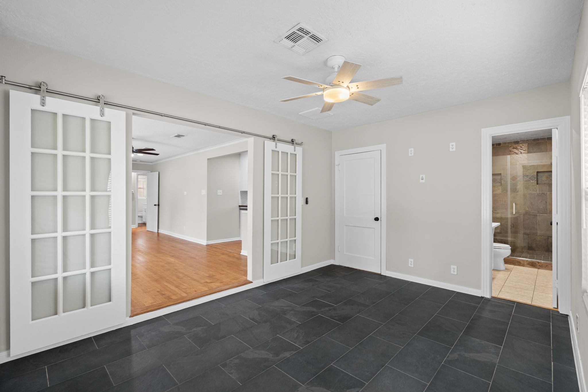 2007 Wakefield Drive Houston, TX 77018 - Photo 16 of 29 Enjoy the privacy and comfort of a fully updated primary bedroom. Spacious and bright, it includes a modern en suite bathroom, a generous closet, and elegant sliding barn doors—ideal for relaxing after a long day.