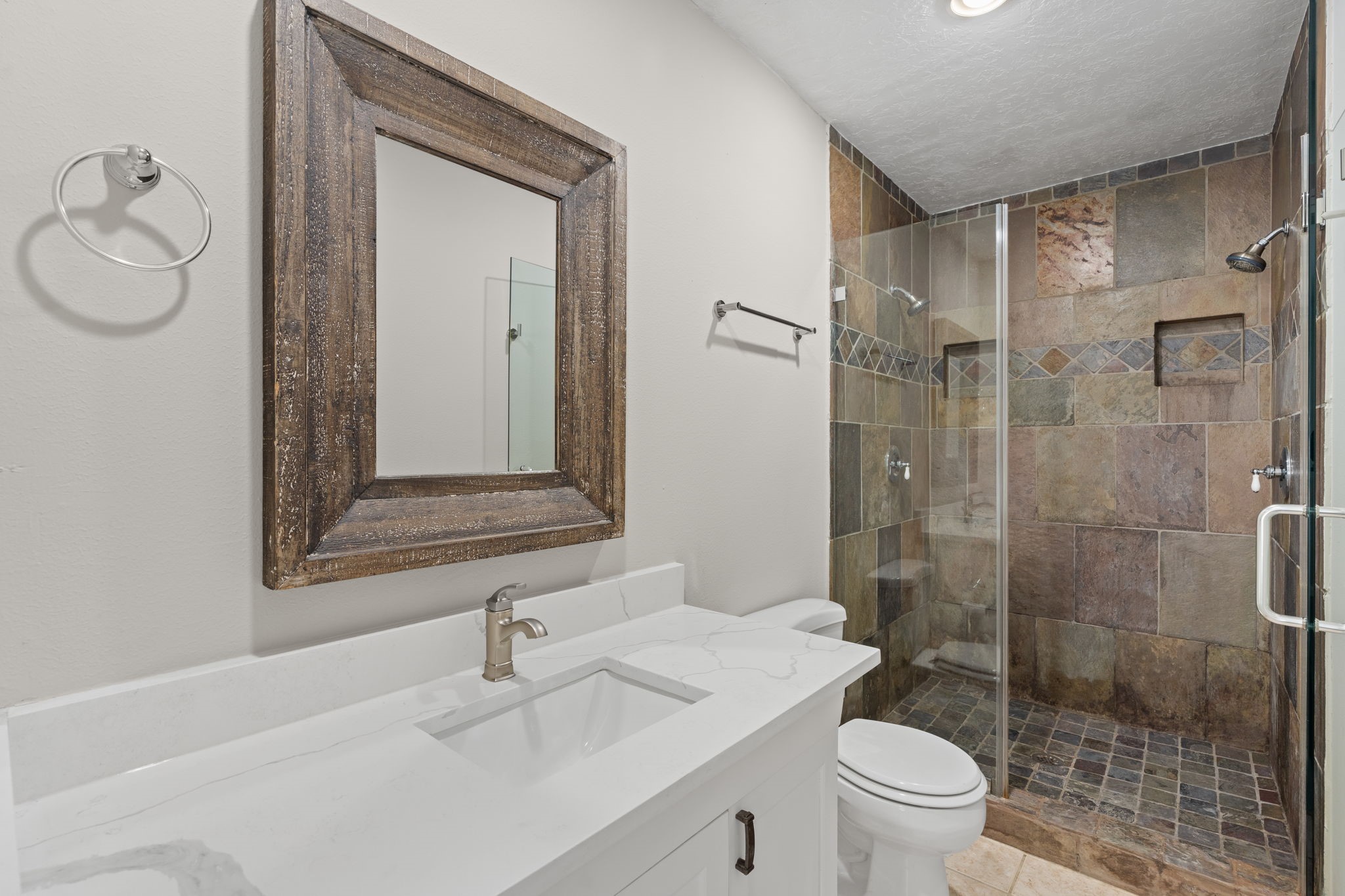 2007 Wakefield Drive Houston, TX 77018 - Photo 18 of 29 The fully updated primary bathroom is designed for both style and convenience. Featuring dual shower heads, modern finishes, and a spacious layout, it offers a luxurious and practical retreat for everyday living.