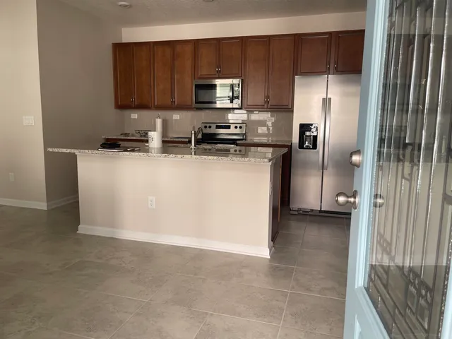 a kitchen with a refrigerator and a stove top oven