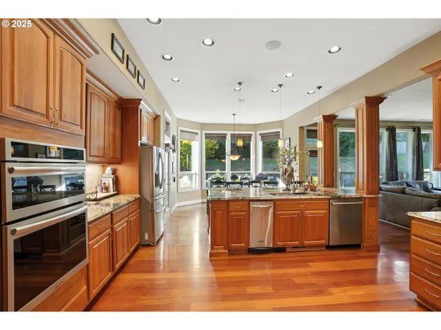 a kitchen with stainless steel appliances granite countertop a sink and refrigerator