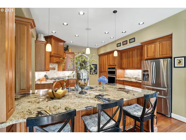 a kitchen with stainless steel appliances granite countertop a refrigerator stove and sink