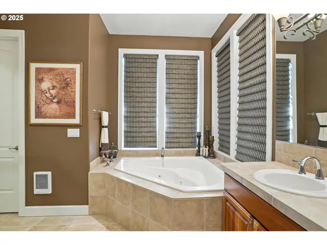 a large bathroom with a large tub double vanity sink and a large mirror