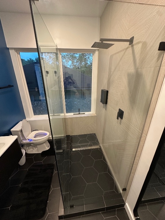 3210 Hampton Road, Unit A B C Austin, TX 78705 - Photo 11 of 39 Full bathroom featuring a stall shower, dark tile patterned flooring, and vanity