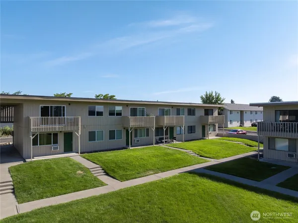 a front view of residential houses with yard and green space
