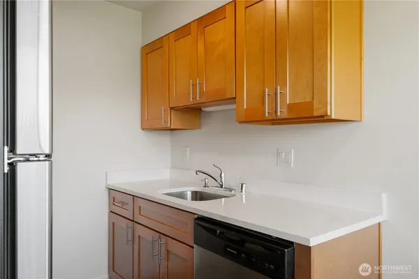 a kitchen with a refrigerator and wooden floor