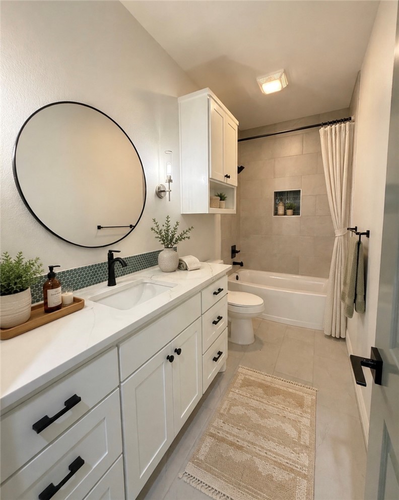 3245 Hunters Crossing Bryan, TX 77808 - Photo 18 of 30 Modern bathroom featuring an extended white vanity with integrated sink, black hardware, and a circular wall mirror floor to ceiling designer tile with niche and head knocker cabinets for plenty of storage