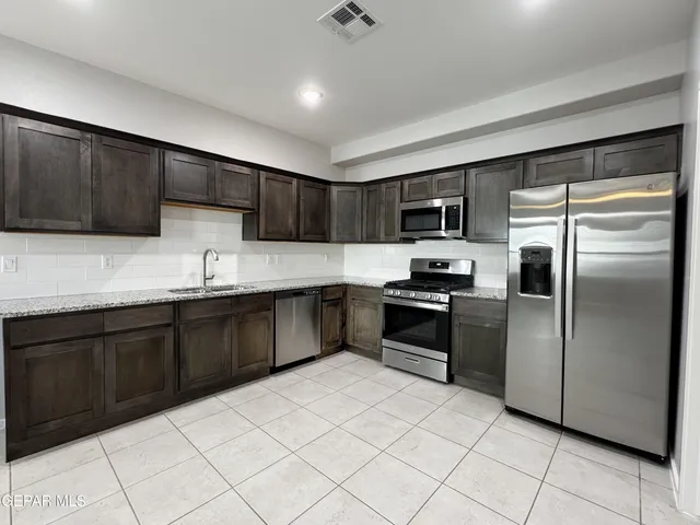 an empty room with kitchen view