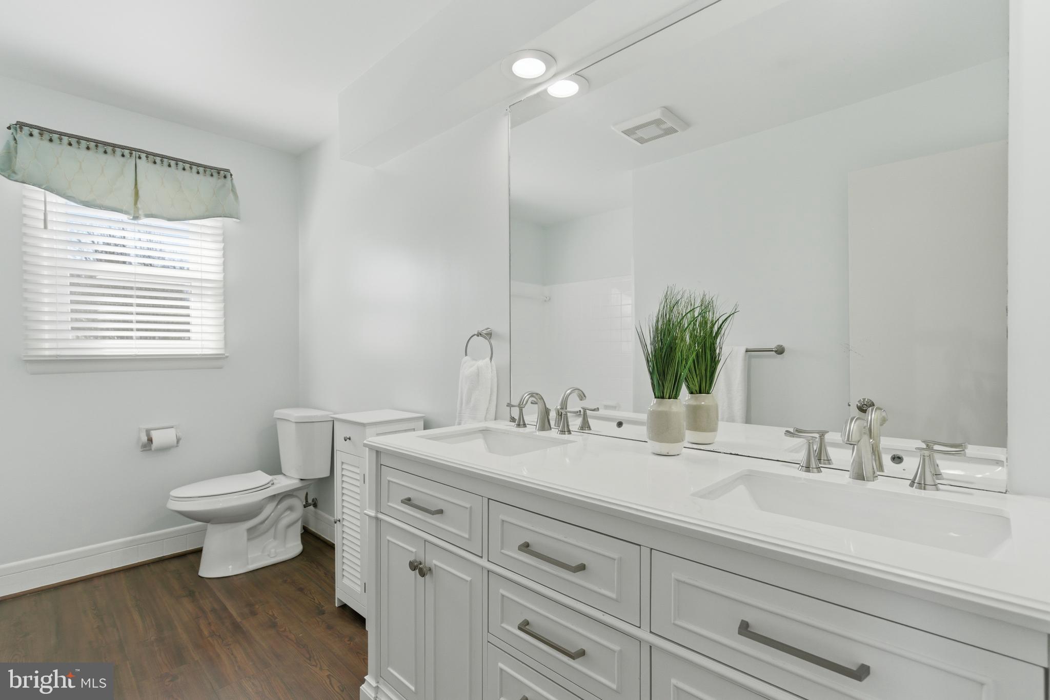 5020 Alta Vista Road Bethesda, MD 20814 - Photo 22 of 41 a bathroom with a double vanity sink toilet and a mirror