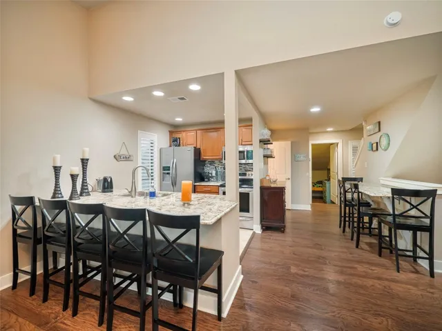 a dining room with stainless steel appliances a table and chairs