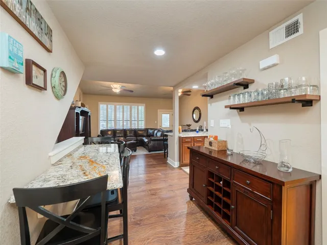 a kitchen with stainless steel appliances kitchen island granite countertop a stove a sink a dining table and chairs