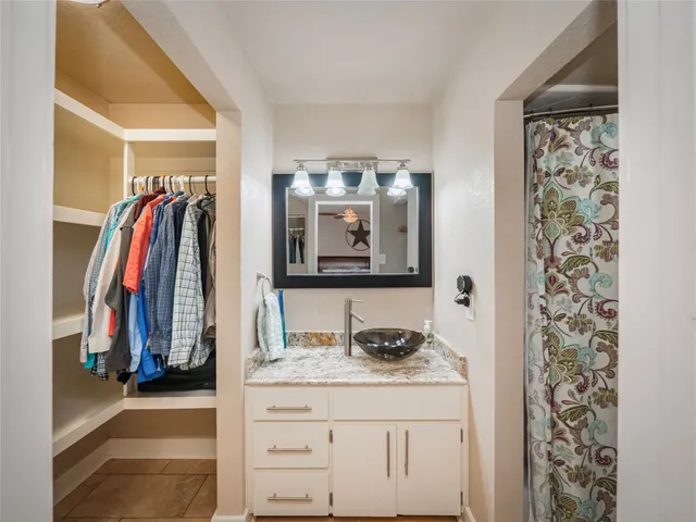 a view of walk in closet with clothes