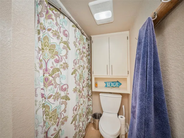 a white toilet sitting next to a shower curtain