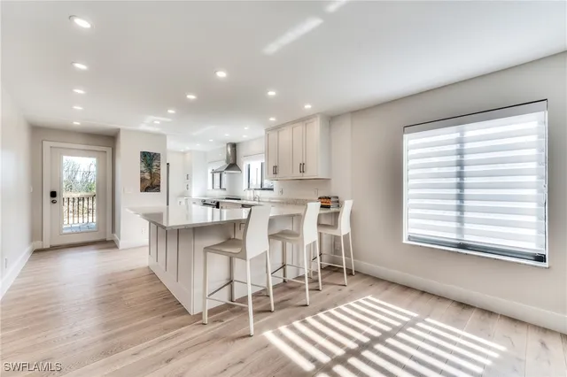 a view of kitchen with kitchen island wooden floor center island and stainless steel appliances