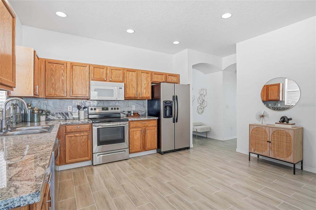 12351 Ridgedale Drive Hudson, FL 34669 - Photo 13 of 48 a kitchen with stainless steel appliances granite countertop a refrigerator sink and stove