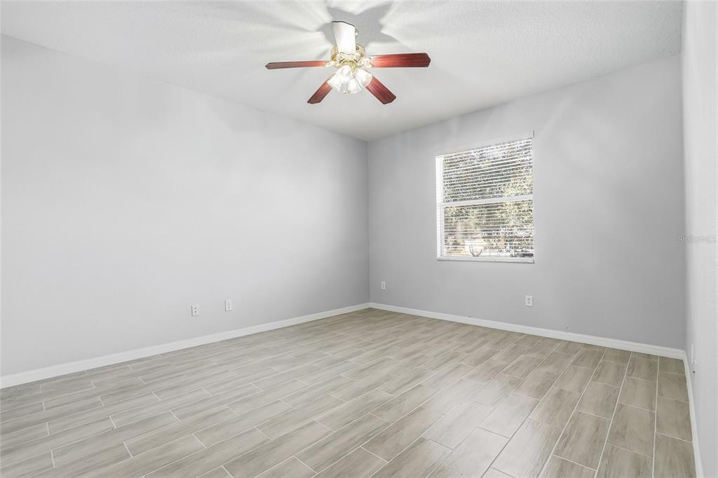 12351 Ridgedale Drive Hudson, FL 34669 - Photo 19 of 48 an empty room with wooden floor and windows