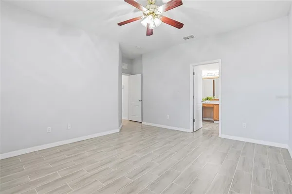 a view of an empty room with window and wooden floor