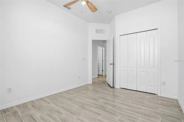 an empty room with wooden floor and bathroom view