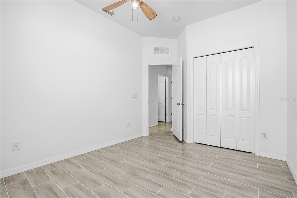 12351 Ridgedale Drive Hudson, FL 34669 - Photo 30 of 48 an empty room with wooden floor and bathroom view