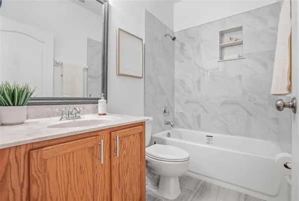 a bathroom with a granite countertop sink a toilet and shower