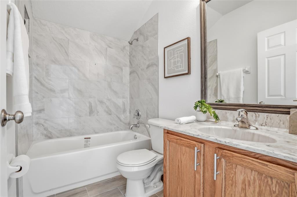12351 Ridgedale Drive Hudson, FL 34669 - Photo 40 of 48 a bathroom with a granite countertop sink toilet mirror and bathtub