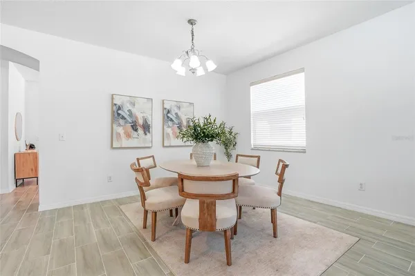 a dining room with furniture a rug and a chandelier
