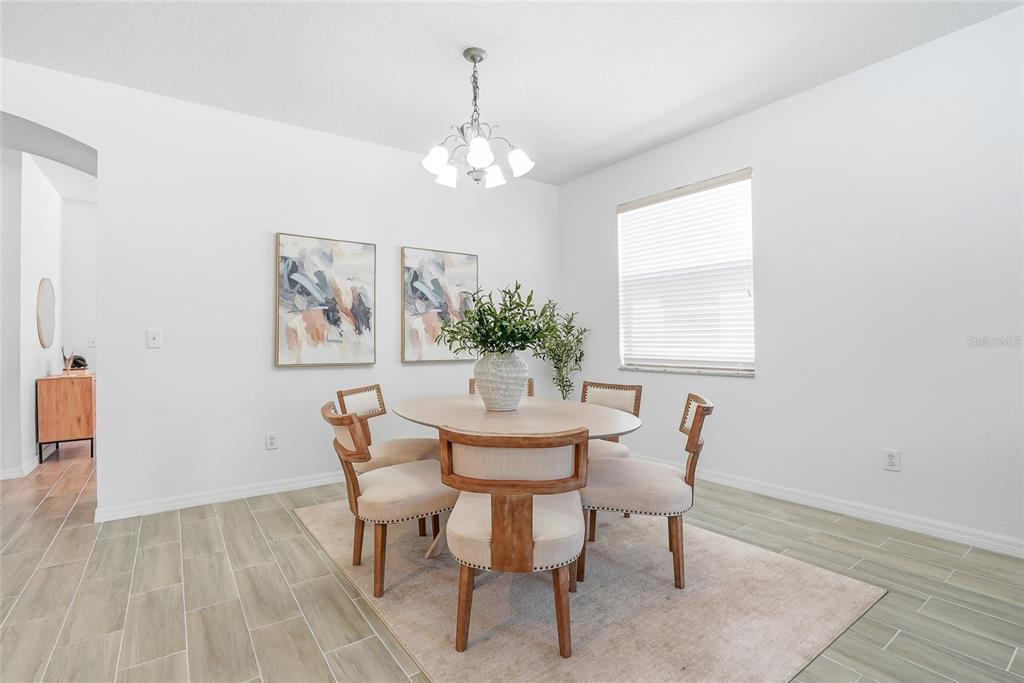 12351 Ridgedale Drive Hudson, FL 34669 - Photo 6 of 48 a dining room with furniture a rug and a chandelier
