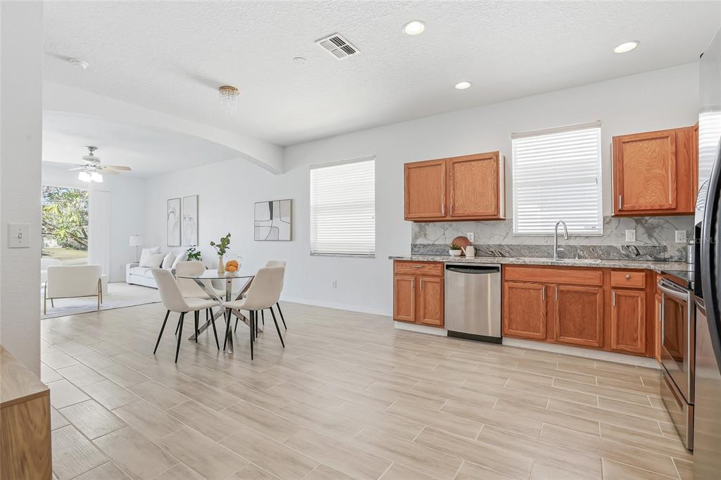 12351 Ridgedale Drive Hudson, FL 34669 - Photo 8 of 48 a large kitchen with stainless steel appliances granite countertop a stove a sink a dining table and chairs