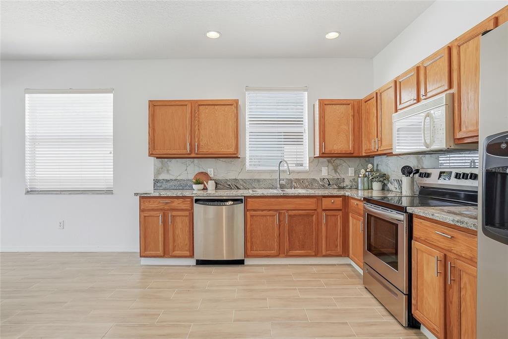 12351 Ridgedale Drive Hudson, FL 34669 - Photo 9 of 48 a kitchen with stainless steel appliances granite countertop a stove a sink and a microwave