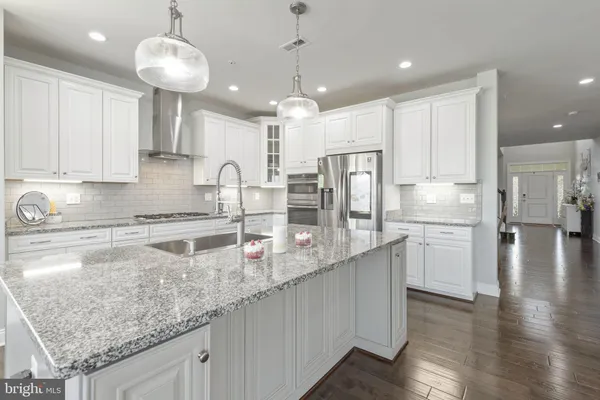 a kitchen with stainless steel appliances granite countertop a lot of counter space and wooden floor