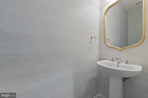 a spacious bedroom with a bed a chandelier and windows