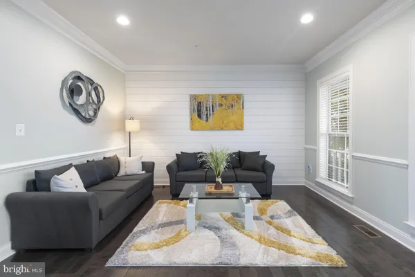 a dining room with furniture wooden floor a chandelier and a painting