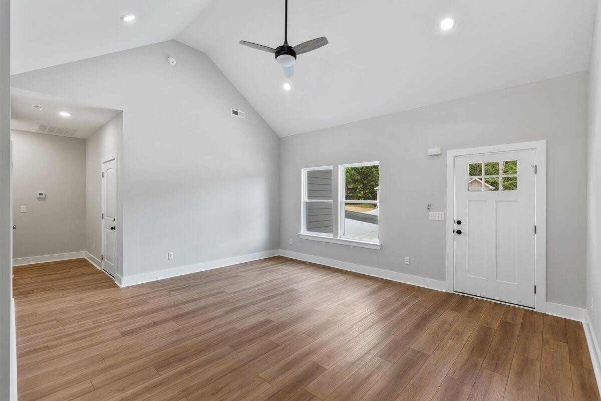 129 County Road 155 Riceville, TN 37370 - Photo 7 of 31 an empty room with wooden floor ceiling fan and windows