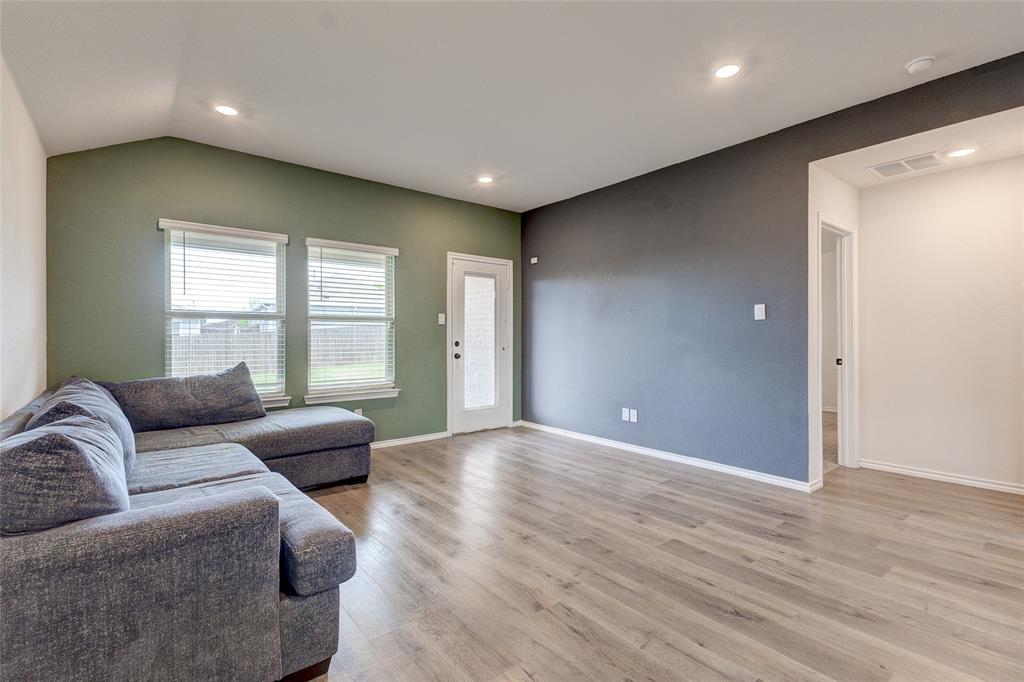 1016 Rio Bravo Drive Forney, TX 75126 - Photo 9 of 25 Vaulted ceiling living area featuring wood-finish flooring, recessed lighting, and a glass-paneled door