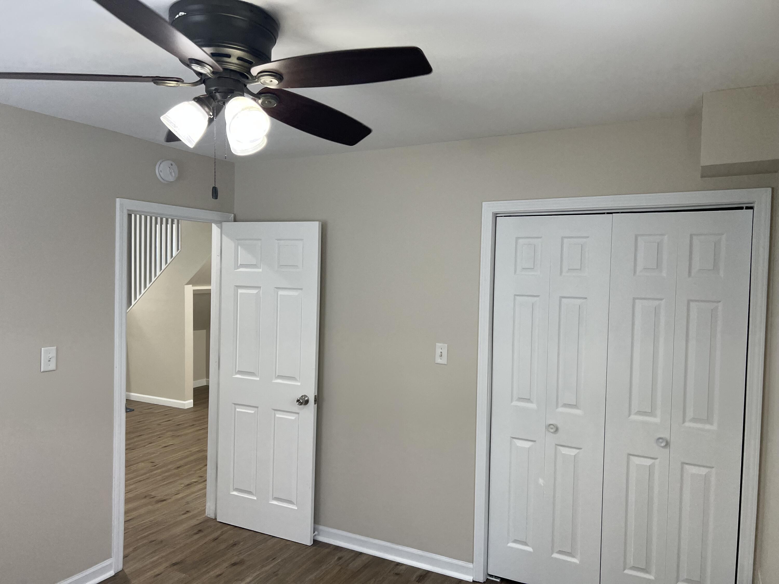 3851 Maple Street Hobart, IN 46342 - Photo 12 of 28 an empty room with wooden floor fan and windows