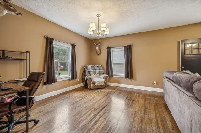 a kitchen with a refrigerator a sink dishwasher a dining table and chairs with wooden floor