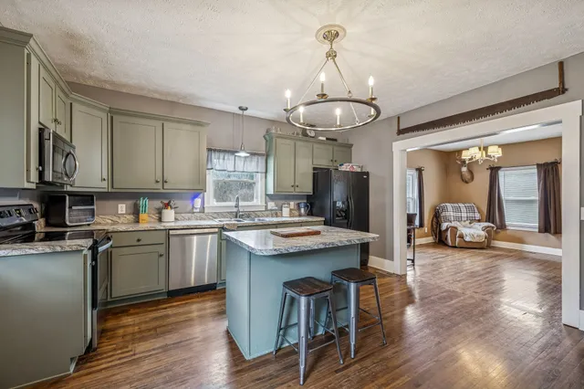 a kitchen with a stove and wooden floor