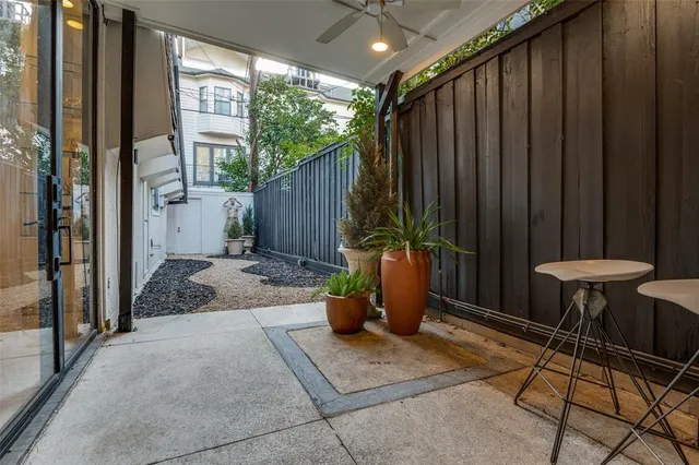 a view of a porch with potted plants and floor to ceiling window