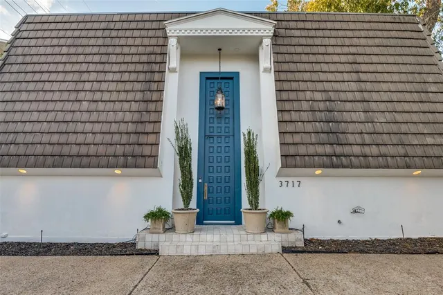 a front view of a house with potted plants