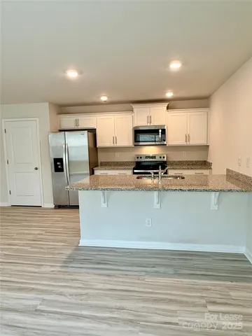 a kitchen with stainless steel appliances granite countertop a stove a sink and a refrigerator